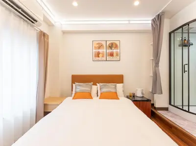 a bedroom with a bed with white sheets and orange pillows at Tabist HOTEL UENO 39 in Tokyo