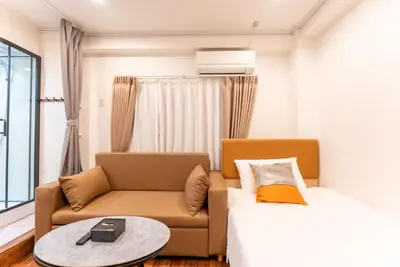 a living room with a couch and a bed at Tabist HOTEL UENO 39 in Tokyo
