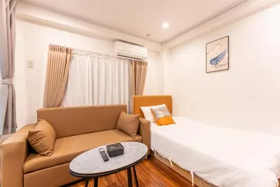 a room with a couch and a bed and a table at Tabist HOTEL UENO 39 in Tokyo