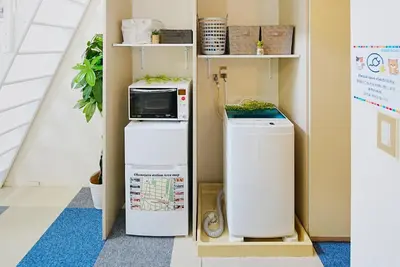 a microwave on top of a refrigerator in a room at SC 105 Cozy Private Stay with Loft Near Station Free WiFi in Tokyo