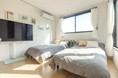 two beds in a room with a large window at NewOpen,\u65b0\u5bbf,\u4e2d\u91ce,SHINJUKU,NAKANO,Parkview,Art,trias234 vacation stay in Tokyo