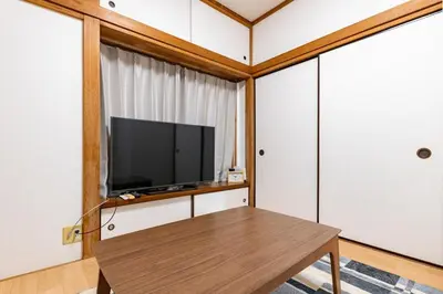 a living room with a tv and a wooden table at tokyo \u738b\u5b50 hotel in Tokyo
