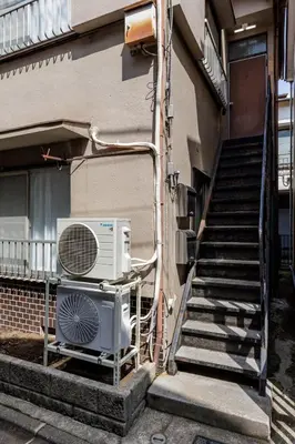 an air conditioner on a rack next to a building at Perfect for sightseeing in Tokyo! 6 people! \u56db\u3064\u6728 in Tokyo