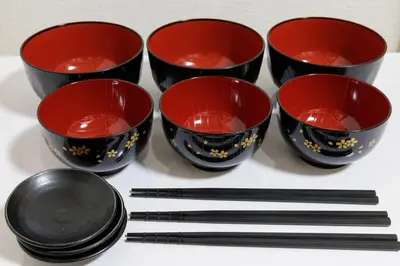 four red and black bowls and chopsticks on a table at Perfect for sightseeing in Tokyo! 6 people! \u56db\u3064\u6728 in Tokyo