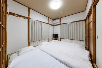 a large white bed in a room with windows at Perfect for sightseeing in Tokyo! 6 people! \u56db\u3064\u6728 in Tokyo