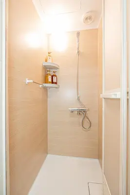 a shower in a bathroom with a wooden wall at Komorebi Asakusa Cozy 4P Stay The 77 House Tokyo in Tokyo