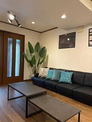a living room with a black couch and a coffee table at \u79cb\u8449\u539f in Tokyo