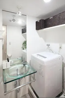 a bathroom with a sink and a washing machine at Shirogane Apartment in Tokyo