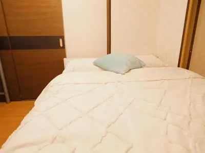 a large white bed with a blue pillow on it at 302Near Ueno Heart of city in Tokyo