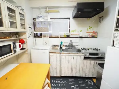 a small kitchen with white appliances and a table at 302Near Ueno Heart of city in Tokyo