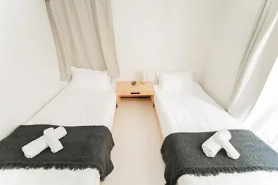two beds in a small room with crosses on them at GJbb \u5c0f\u5ca9\u99c5\u304b\u3089\u5f92\u6b696\u5206 \u7fbd\u7530\u7a7a\u6e2f\u6210\u7530\u7a7a\u6e2f\u884c\u304d\u306e\u76f4\u884c\u30d0\u30b9 \u5b50\u9023\u308c in Tokyo