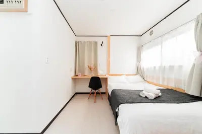 a bedroom with two beds and a window at GJbb \u5c0f\u5ca9\u99c5\u304b\u3089\u5f92\u6b696\u5206 \u7fbd\u7530\u7a7a\u6e2f\u6210\u7530\u7a7a\u6e2f\u884c\u304d\u306e\u76f4\u884c\u30d0\u30b9 \u5b50\u9023\u308c in Tokyo
