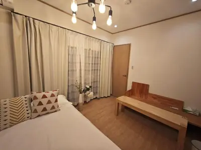 a bedroom with a bed and a bench and a window at ZYZ Sakuradai House NR0259 in Tokyo