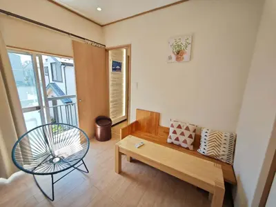 a living room with a bench and a table at ZYZ Sakuradai House NR0259 in Tokyo