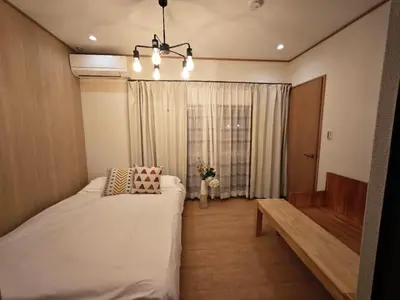 a bedroom with a bed and a bench and a window at ZYZ Sakuradai House NR0259 in Tokyo