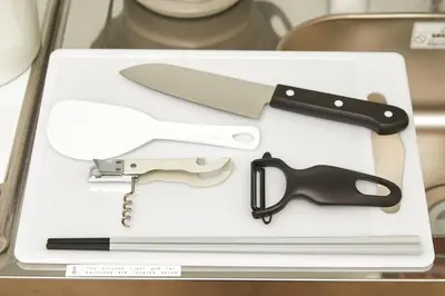 a knife and a gun sitting on a cutting board at Coco Aoto in Tokyo