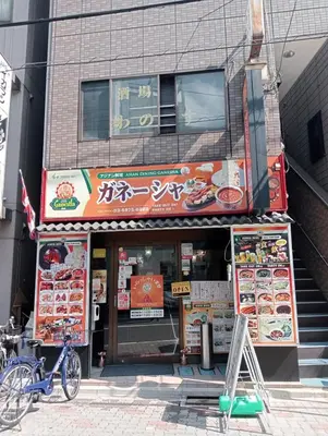a building with a restaurant with signs on it at Coco Aoto in Tokyo