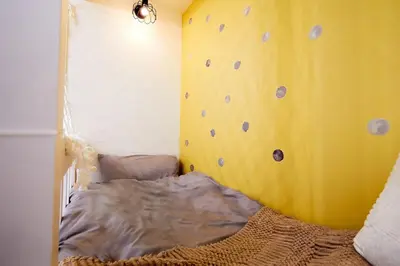 a bedroom with a rock wall with a bed at Coco Aoto in Tokyo