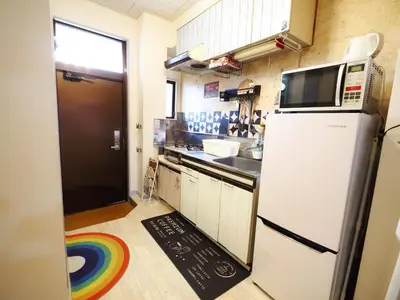 a small kitchen with a refrigerator and a sink at 203 Koiwa Private House in Tokyo