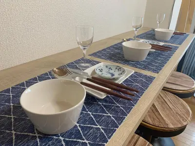 a table with bowls and plates and wine glasses at 203 Koiwa Private House in Tokyo