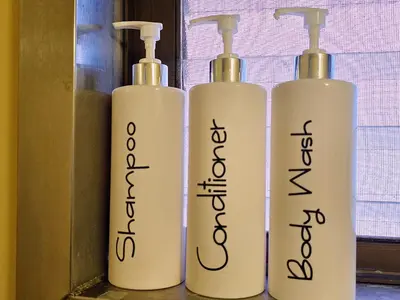 three white bottles with writing on them next to a window at 203 Koiwa Private House in Tokyo