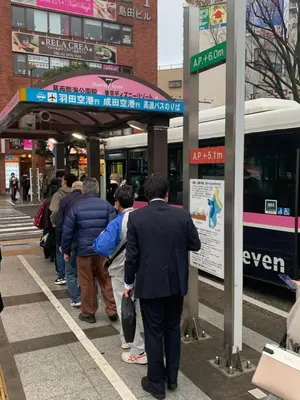 a group of people waiting to get on a bus at 203 Koiwa Private House in Tokyo