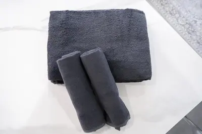 two pieces of gray towels sitting on a table at K'shotel Takadanobaba 山手線駅6分繁華街に近い静かな住宅街のデザイナーズホテル in Tokyo