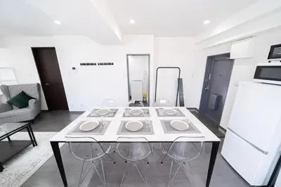 a white table with four chairs in a room at K'shotel Takadanobaba 山手線駅6分繁華街に近い静かな住宅街のデザイナーズホテル in Tokyo
