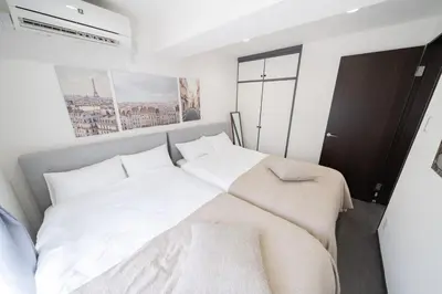 a bedroom with a large bed with white sheets and pillows at K'shotel Takadanobaba 山手線駅6分繁華街に近い静かな住宅街のデザイナーズホテル in Tokyo