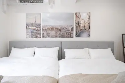 two beds in a bedroom with two pictures on the wall at K'shotel Takadanobaba 山手線駅6分繁華街に近い静かな住宅街のデザイナーズホテル in Tokyo