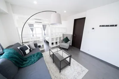 a living room with a couch and a table at K'shotel Takadanobaba 山手線駅6分繁華街に近い静かな住宅街のデザイナーズホテル in Tokyo