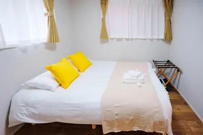 a bedroom with a white bed with yellow pillows at SCD312 Eight subway lines connect to Tokyo business district, scarce 2 bathrooms, 2 toilets, warm space in Tokyo