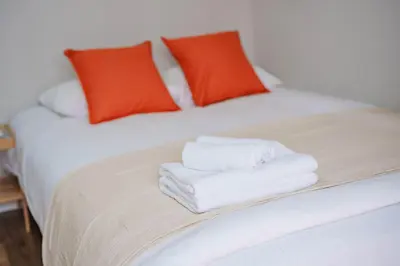 a bed with white towels on it with red pillows at SCD312 Eight subway lines connect to Tokyo business district, scarce 2 bathrooms, 2 toilets, warm space in Tokyo