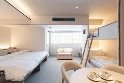 a room with two beds and a table and a chair at ENT TERRACE Asakusabashi in Tokyo