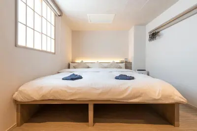 a bedroom with a bed with two blue towels on it at ENT TERRACE Asakusabashi in Tokyo