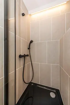 a bathroom with a shower with a black shower head at ENT TERRACE Asakusabashi in Tokyo