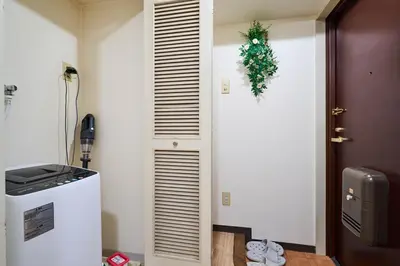 a kitchen with a refrigerator and a door with a wreath at \u5e73\u548c\u5cf6801 in Tokyo