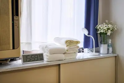 a pile of towels sitting on a counter next to a window at \u5e73\u548c\u5cf6801 in Tokyo