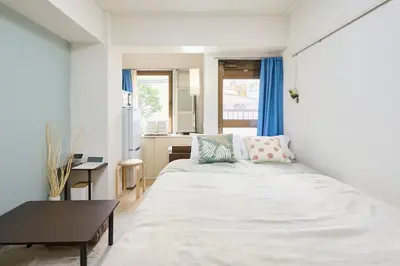 a bedroom with a bed and a table and a kitchen at \u5e73\u548c\u5cf6202 in Tokyo