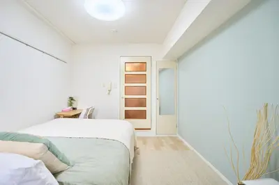a white bedroom with a bed and a door at \u5e73\u548c\u5cf6202 in Tokyo