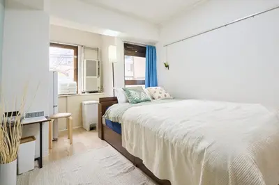 a bedroom with a bed and a desk and a window at \u5e73\u548c\u5cf6202 in Tokyo