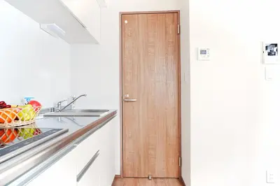 a kitchen with a wooden door and a sink at Nakano Cozy House\u4e2d\u91ce\u30b3\u30fc\u30b8\u30fc\u30cf\u30a6\u30b9 in Tokyo