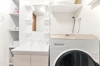 a white laundry room with a washer and dryer at Nakano Cozy House\u4e2d\u91ce\u30b3\u30fc\u30b8\u30fc\u30cf\u30a6\u30b9 in Tokyo