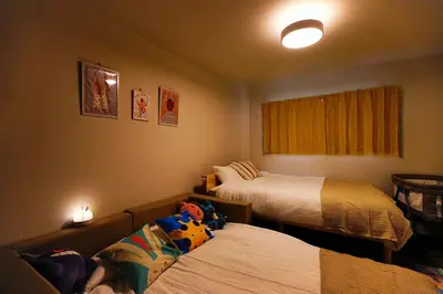 a hotel room with two beds and a couch at Nakano Cozy House\u4e2d\u91ce\u30b3\u30fc\u30b8\u30fc\u30cf\u30a6\u30b9 in Tokyo