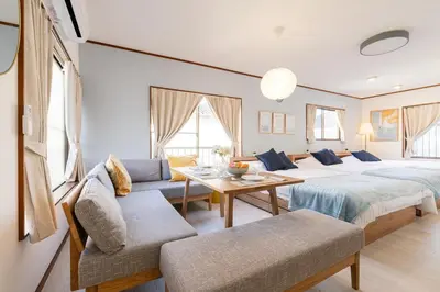a bedroom with two beds and a table and chairs at tai\u4e0a\u5317\u6ca24\u4e01\u76ee in Tokyo