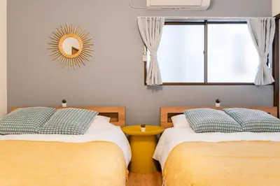 two beds in a room with a mirror and a window at tai\u4e0a\u5317\u6ca24\u4e01\u76ee in Tokyo
