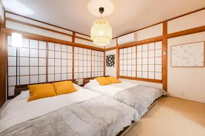 two twin beds in a room with windows at tai\u4e0a\u5317\u6ca24\u4e01\u76ee in Tokyo