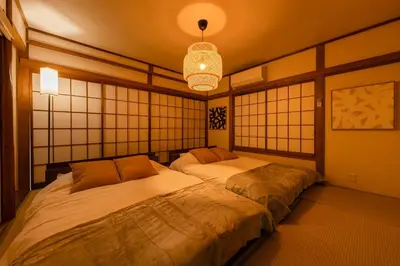 two twin beds in a room with a chandelier at tai\u4e0a\u5317\u6ca24\u4e01\u76ee in Tokyo