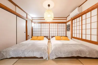 two beds in a room with large windows at tai\u4e0a\u5317\u6ca24\u4e01\u76ee in Tokyo