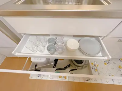an open refrigerator drawer with dishes and utensils at Sakura Stay \u62bc\u4e0a in Tokyo
